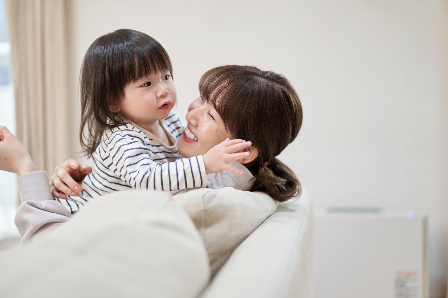 Asian kid hugging mom vigorously